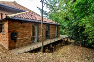 a brick house with a porch and a deck at Tawny Lodge in York