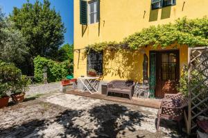 a yellow house with chairs outside of it at Casa Anita Lucca in Lucca