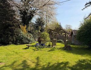 a garden with a wooden gazebo in a yard at Mesopotamia Cottage in Clifton Hampden