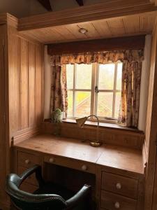 a desk with a chair in front of a window at Mesopotamia Cottage in Clifton Hampden +51 photos