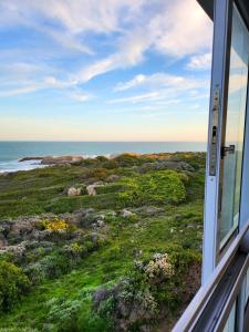 a window view of the ocean from a house at Klipfontein House in Kleinbaai