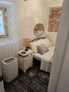 a small bedroom with a bed and a mirror at Artisana Silba in Silba +60 photos