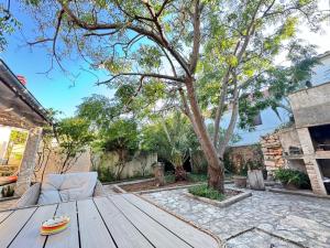 a wooden table and chairs in a yard with a tree at Artisana Silba in Silba