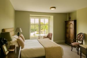 a bedroom with a bed and a table and a window at The Lion Hotel in Builth Wells