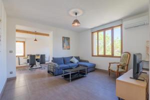 a living room with a blue couch and a tv at Gite en sud-ardèche avec jacuzzi in Joyeuse
