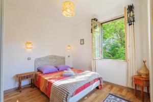 a bedroom with a bed and a window at Gite en sud-ardèche avec jacuzzi in Joyeuse
