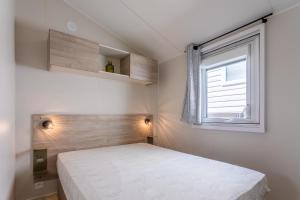a bedroom with a white bed and a window at Gassin bungalow in Gassin