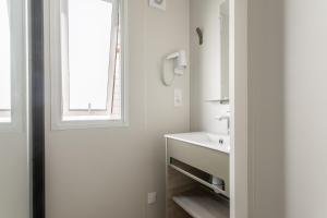 a white bathroom with a sink and a window at Gassin bungalow in Gassin +19 photos