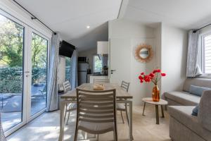 a dining room and living room with a table and chairs at Gassin bungalow in Gassin