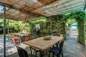 a patio with a wooden table and chairs under a pergola at Casa Anita Lucca in Lucca