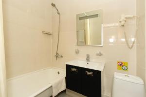 a bathroom with a sink and a tub and a toilet at Hotel Druzhba in Blagoveshchensk
