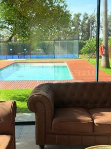 a couch sitting in front of a swimming pool at Villa Paraíso in Seville