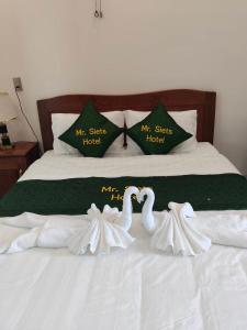 two swans made to look like birds sitting on a bed at MR SIETS hotel in Châu Xá