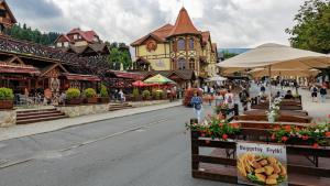 a street in a town with people walking down the street at Hotel Kolorowa in Karpacz