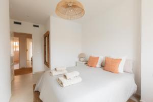a bedroom with a white bed with towels on it at ALOJAMIENTO ARENAL PARK in Jávea +58 photos