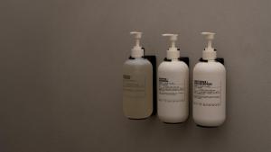 a group of four white bottles sitting on a wall at Hotel âme in Rotterdam +35 photos