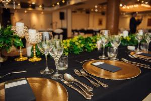 a table with wine glasses and silverware on a table at Hotel Bosna Banja Luka in Banja Luka