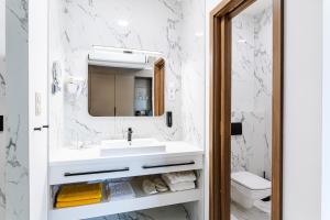 a white bathroom with a sink and a mirror at KQC Boutique Villa in Balatonlelle +15 photos