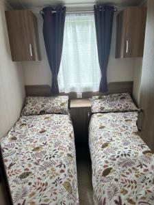 two beds in a small room with a window at Swift Bordeaux 56 in Dunoon