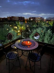 a table and chairs on a balcony with a view at Appartement Au vizir avec Accès au Parc de loisirs in Dar Caïd Layadi