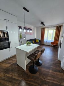 a kitchen and living room with a white table and chairs at Concept Luxury in Mediaş