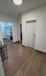 an empty living room with a door and a wooden floor at apartment R in Mrljane