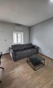 a living room with a couch and a glass coffee table at apartment R in Mrljane
