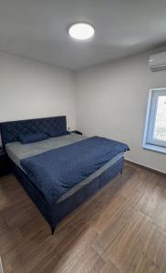 a bedroom with a blue bed in a room at apartment R in Mrljane