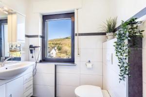 a bathroom with a sink and a window at Ferienwohnung Landblick in Brilon +18 photos