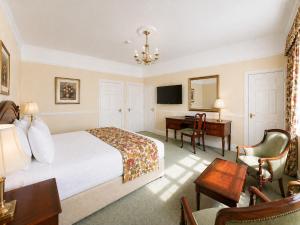 a hotel room with a bed and a desk at Nent Hall Country House Hotel in Nenthead +26 photos