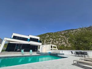 a house with a swimming pool in front of a mountain at The Bunica Residence in Parila