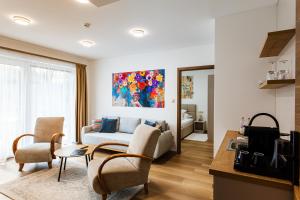 a living room with a couch and a tv in a room at KQC Boutique Villa in Balatonlelle