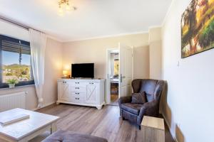 a living room with a chair and a television at Ferienwohnung Landblick in Brilon