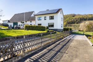 a white house with a fence in front of it at Ferienwohnung Landblick in Brilon