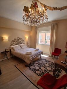 a bedroom with a large bed and a chandelier at Central luxury rooms in Olbia