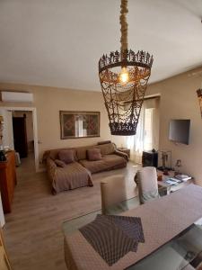 a living room with a chandelier and a couch at Central luxury rooms in Olbia