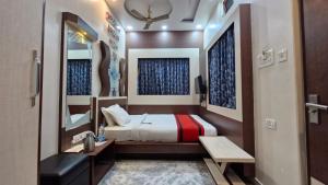 a small bedroom with a bed and a mirror at Hotel Suraj in Raxaul