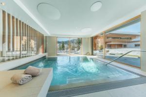 a swimming pool in a house with a large window at Mats Lech Alpenquartier in Lech am Arlberg