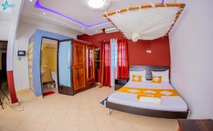 a bedroom with a king sized bed and red walls at Salama Hôtel Majunga in Mahajanga +70 photos