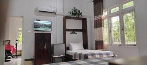 a bedroom with a bed and a tv on the wall at Kandy Home stay - Haloluwa in Katugastota +174 photos