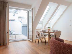 a dining room with a table and chairs and a balcony at MINTNaschmarkt in Vienna