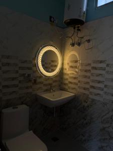 a bathroom with a sink and a toilet and a mirror at Terra Himalayan Homestay in Kasar Devi in Hawālbāgh