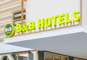 a sign for a bbq hotel on a building at B&B HOTEL Cap d'Agde Bessan in Bessan