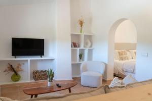 a living room with a bed and a tv at Es Mayolet in Manacor