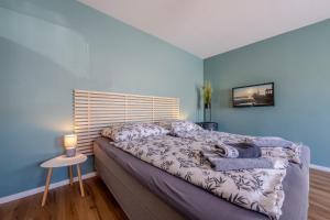 a bedroom with a large bed with blue walls at Gemütliche Ferienwohnung - Araliya 2 in Ahlbeck