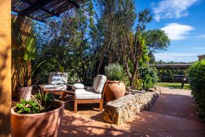 a patio with two chairs and potted plants at Valesmeralda Boutique Rooms, Porto Cervo Marina Adults only in Porto Cervo