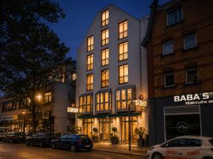 a building on a street with cars parked in front at CityHotel Feuerbach in Stuttgart