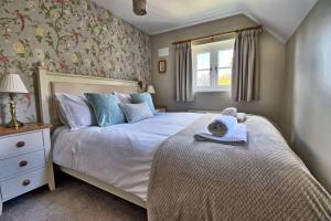 a bedroom with a bed and a window at Martie Cottage - cosy cottage idyllic village in Whitcombe