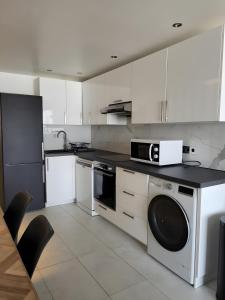 a kitchen with white cabinets and a black counter top at Couleur océan, piscine et plage in Le Croisic +31 photos