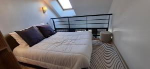 a small bedroom with a bed with blue pillows at Couleur océan, piscine et plage in Le Croisic